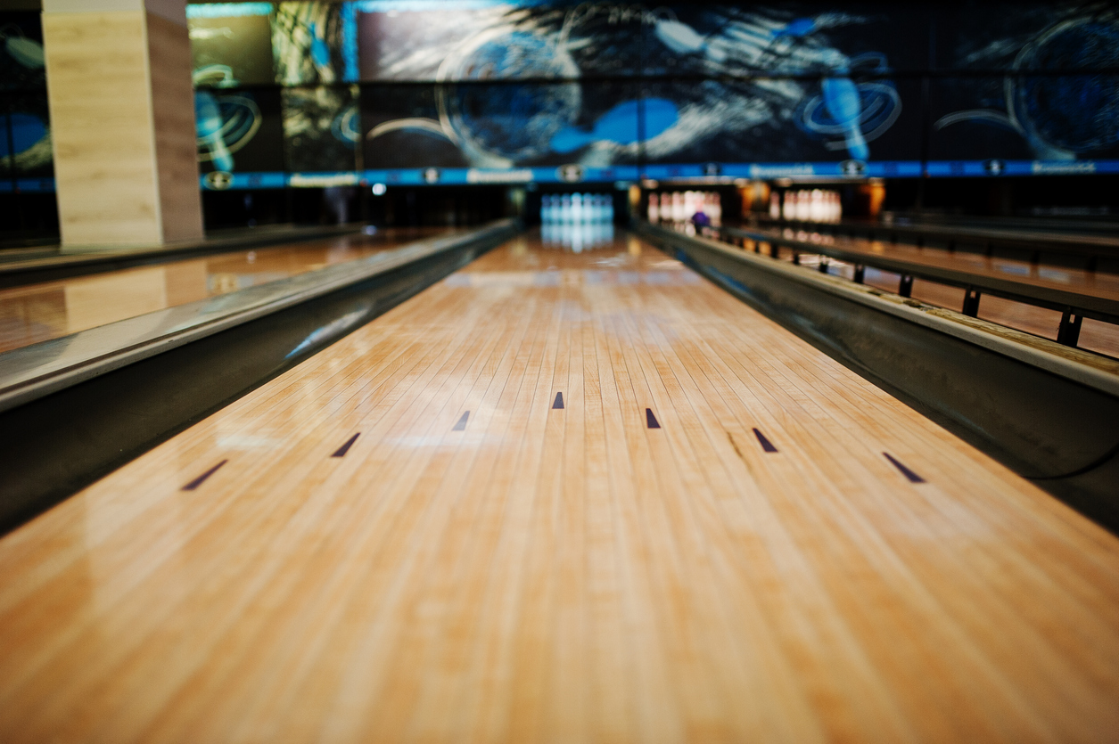 Image taken on the floor of a bowling lane from foul line looking at pins